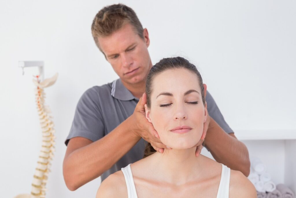 Chiropractor checking patient for TMJ. 